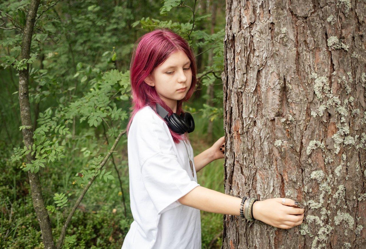 Jeune influenceur éthique partageant une action écologique en forêt, symbolisant la connexion avec la nature.