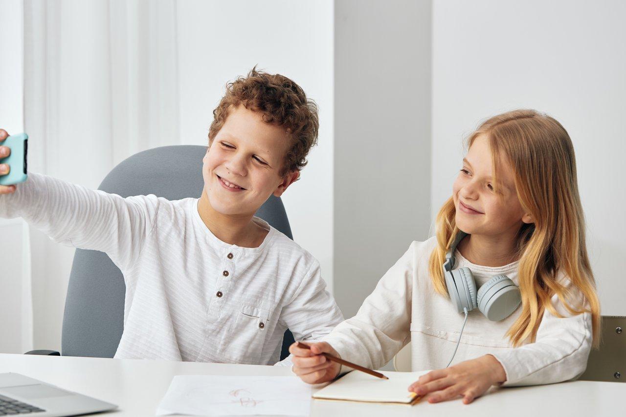 Jeunes créateurs de contenu collaborant avec un smartphone et un ordinateur portable, illustrant leur passion pour le blogging.