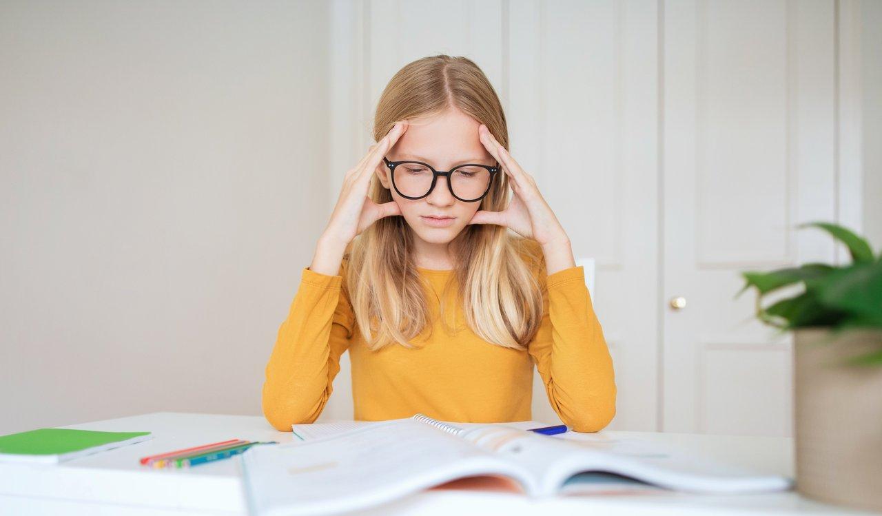 Une adolescente anxieuse face à ses devoirs, illustrant le stress des jeunes confrontés à leur avenir scolaire.